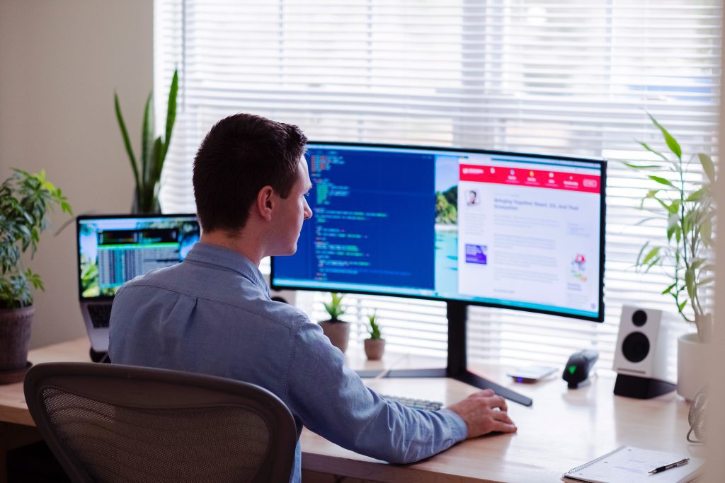 A person working on a dual screen system