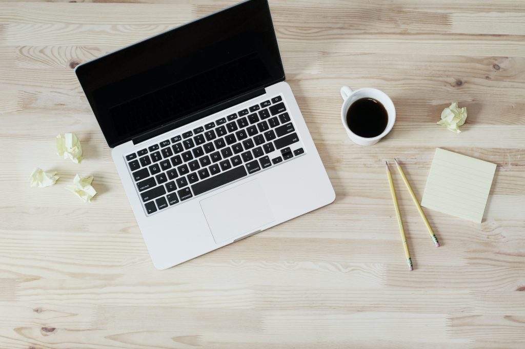 A laptop and a coffee with pencils