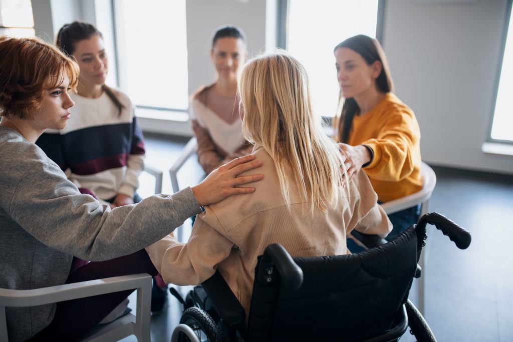 A group of people consoling one lady