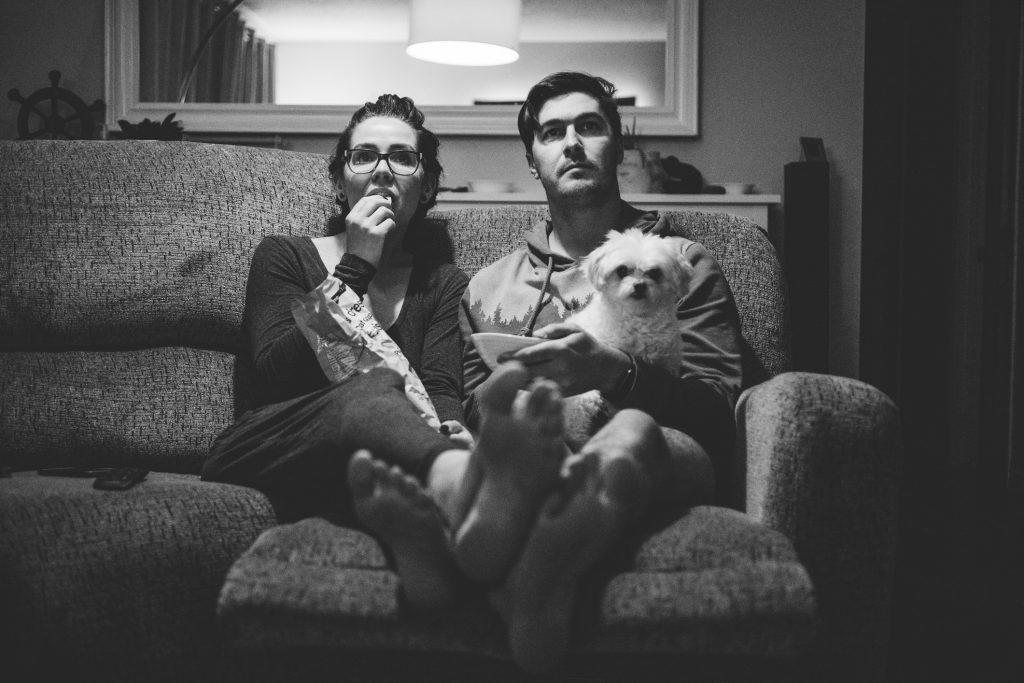 A couple with their dog watching a movie