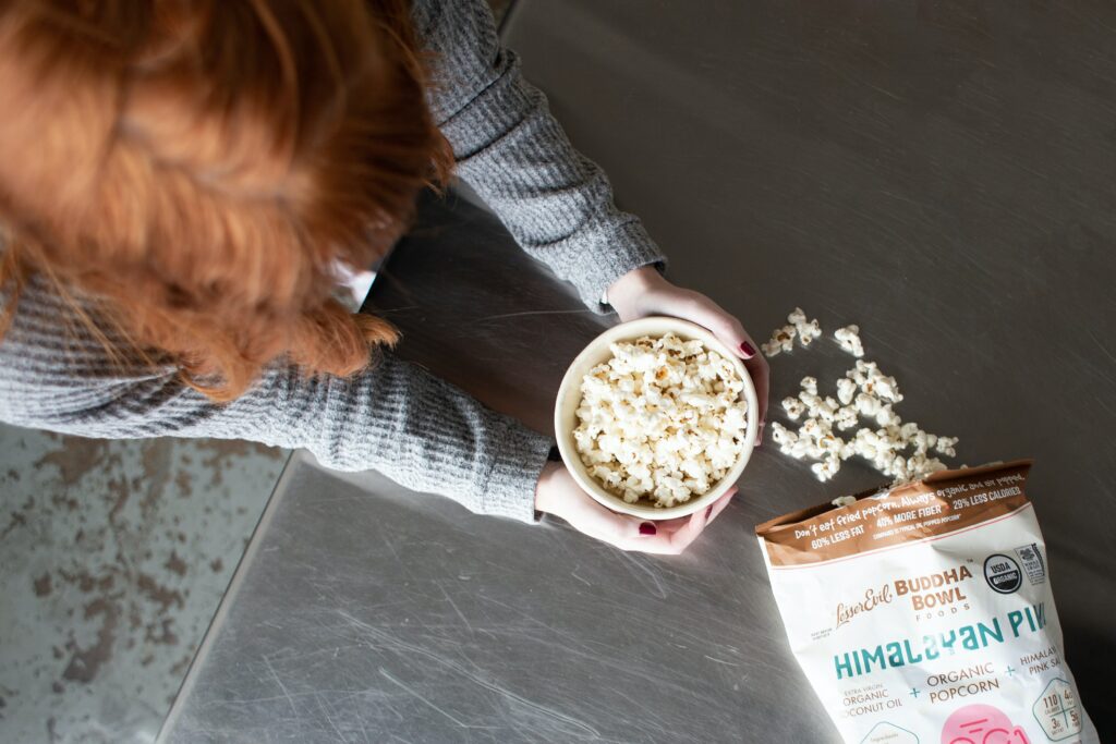 A woman eating popcorn as a snacktivity