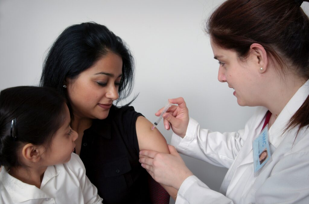 A primary care physician gives a patient a shot