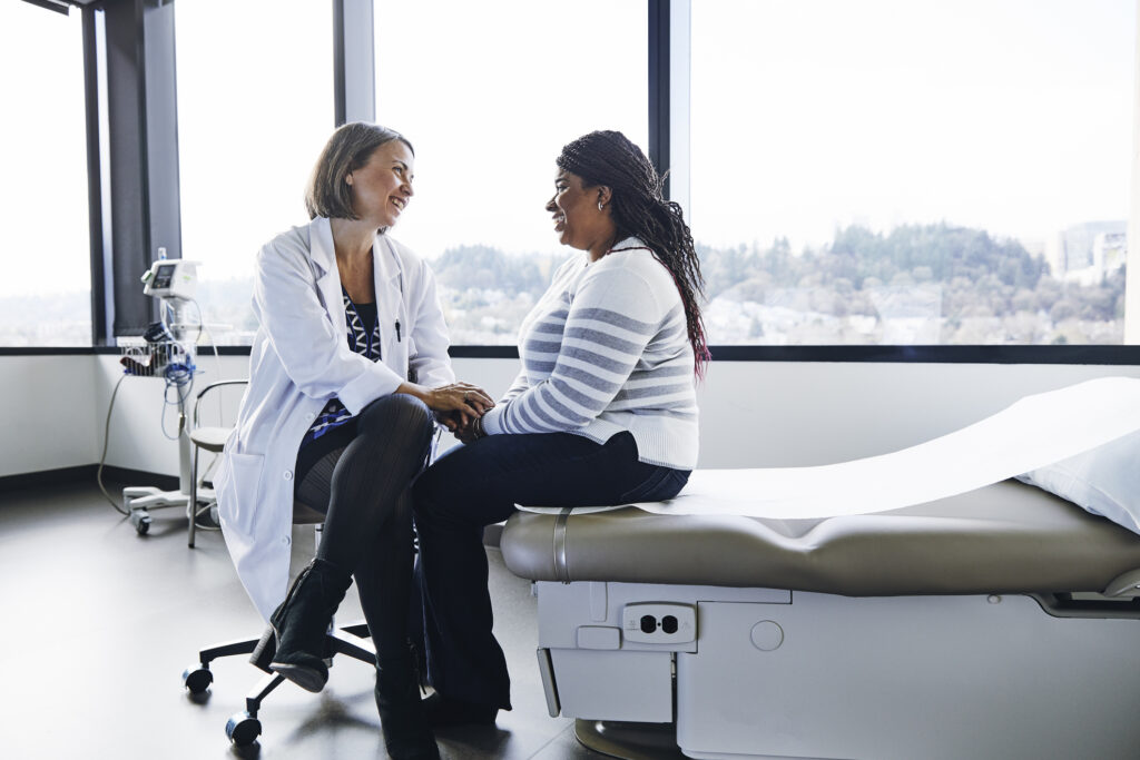 A female doctor comforts a patient in an example of great patient experience, or PX