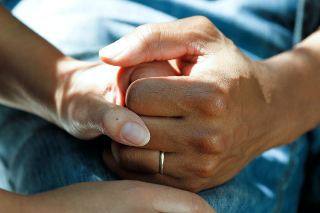 A patient holds hands with someone while they are being comforted