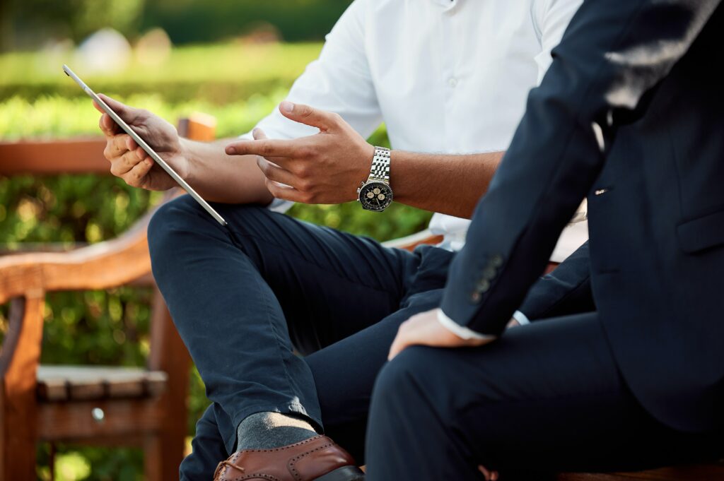 A consultant talks to a client on a park bench