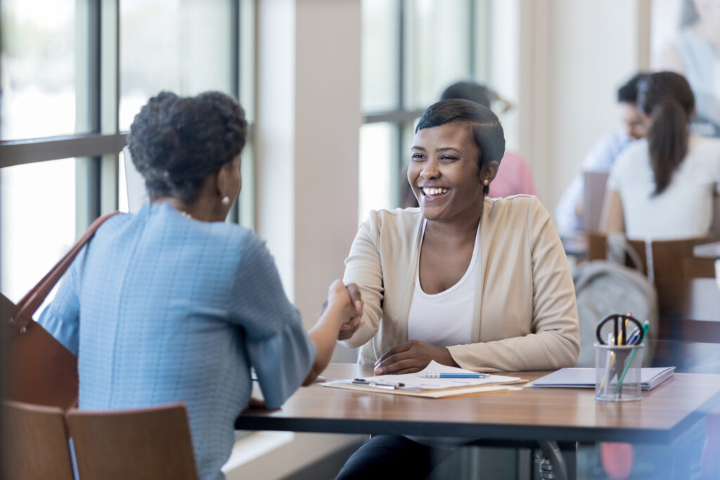 Credit union employee retention in action as a teller happily greets new customer