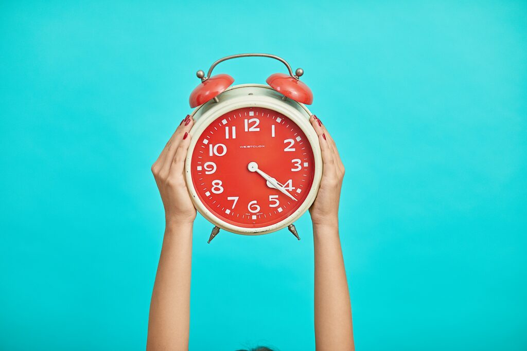 person holding up a clock